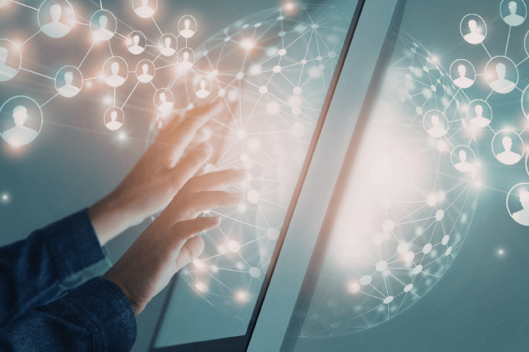 Eine Person bedient einen großen digitalen Bildschirm. Im Hintergrund sind vernetzte Symbole von Personen und eine leuchtende, kugelförmige Netzwerkstruktur zu sehen, die digitale Kommunikation, Vernetzung und Zusammenarbeit symbolisieren.